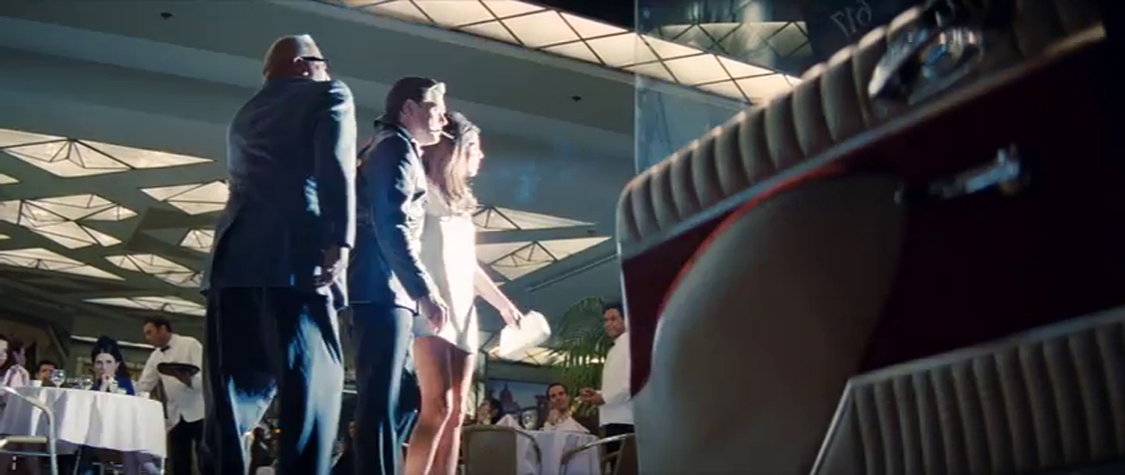 Exterior of Cicada as seen in Once Upon a Time...In Hollywood, a door to a car sits ajar on the right, and flash bulbs pop as DiCaprio and a woman pose for photos. 