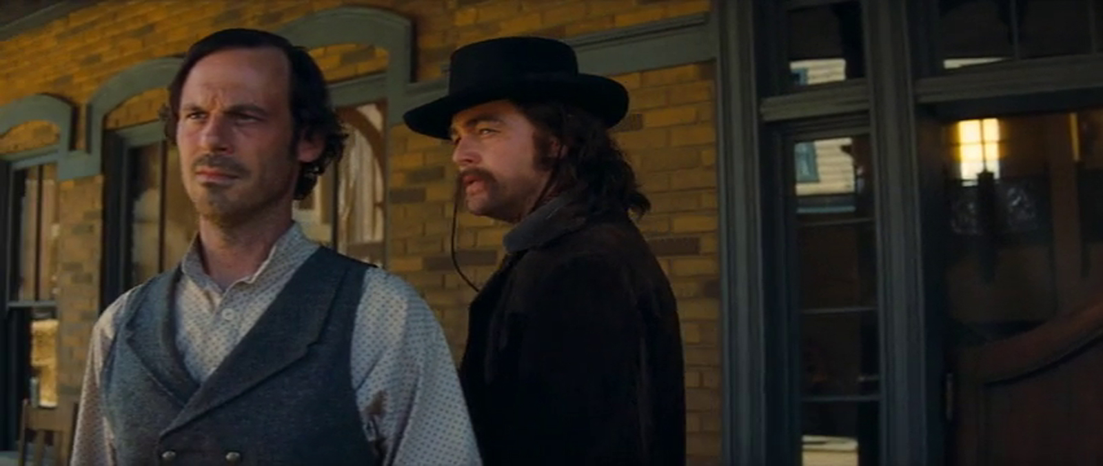 Screencap from Once Upon a Time...In Hollywood, Leonardo DiCaprio, done up in his Lancer duds and make-up looks out from the porch of the saloon.