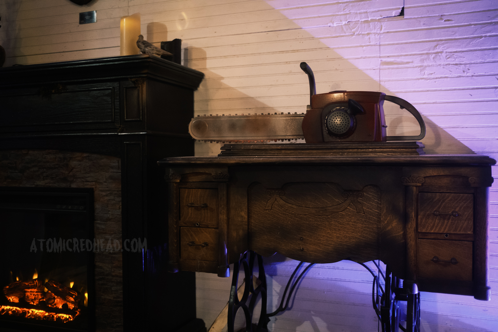 A chainsaw sits atop an antique sewing machine.