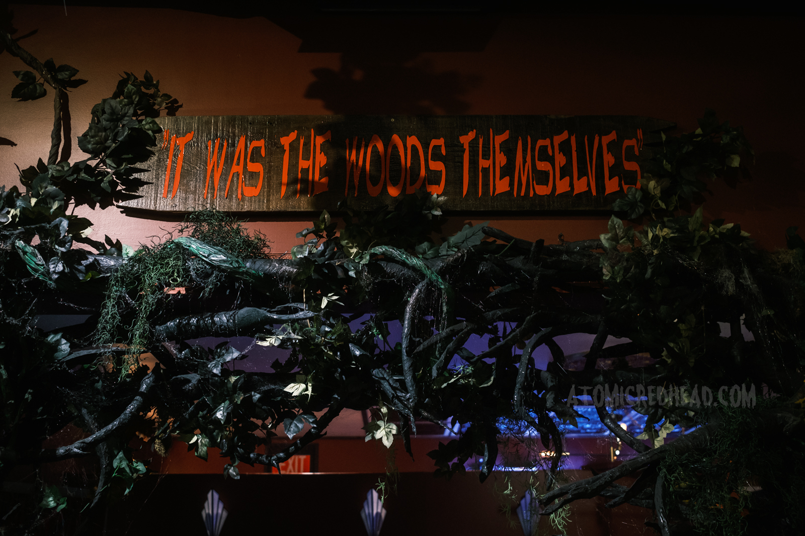 A wood plank reads "It was the woods themselves" in red script.