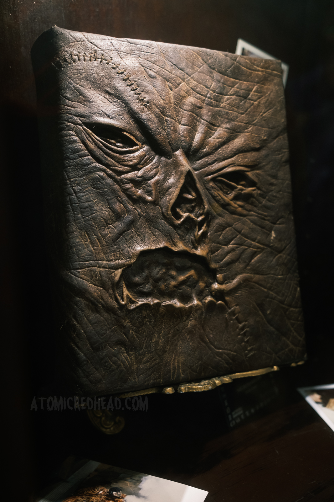Screen used version of the Necronimicon, a book "bound in human flesh" features a warped human face.