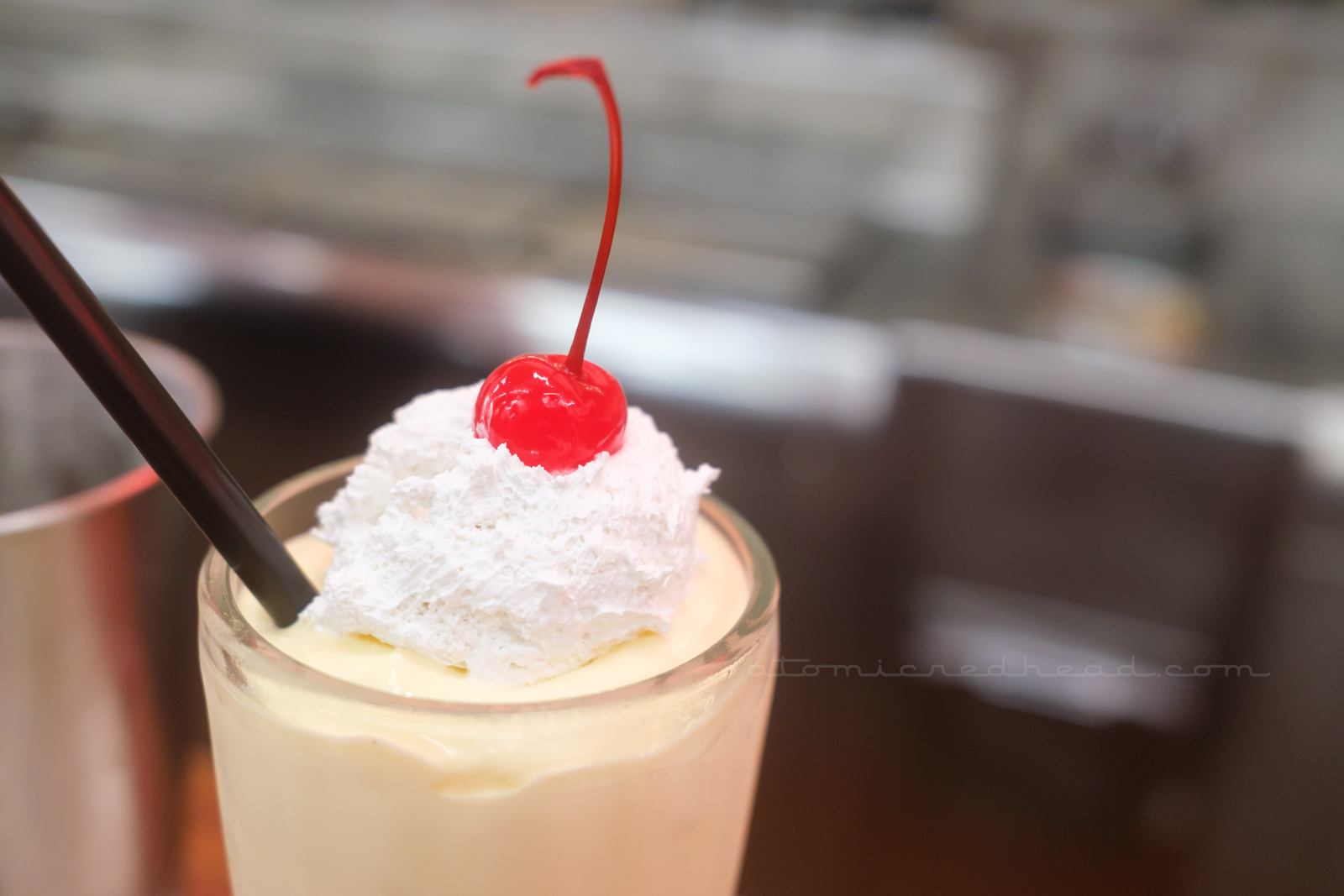 A tasty shake features whipped cream and a cherry on top.