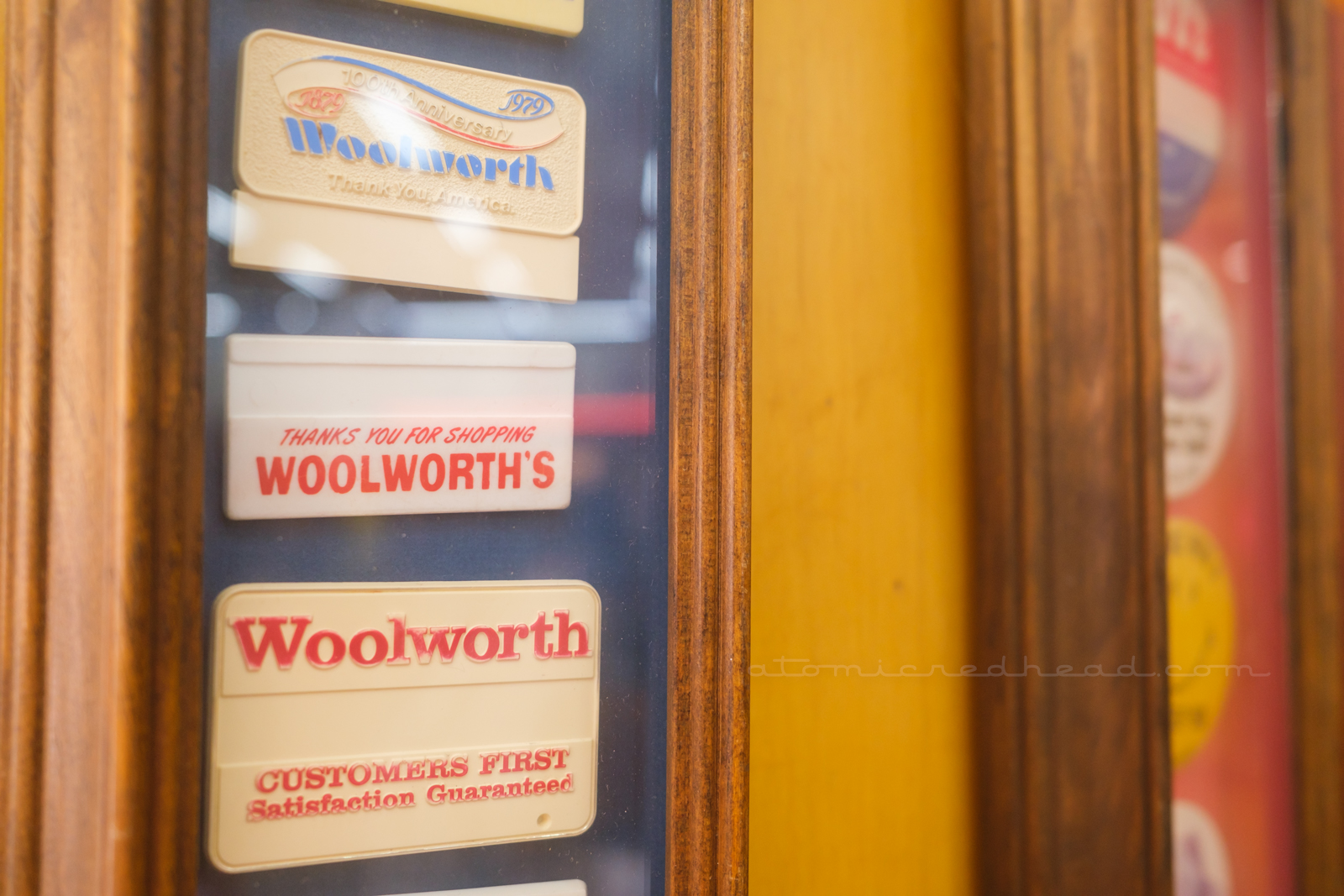 Close-up of a framed set of Woolworth's name badges.