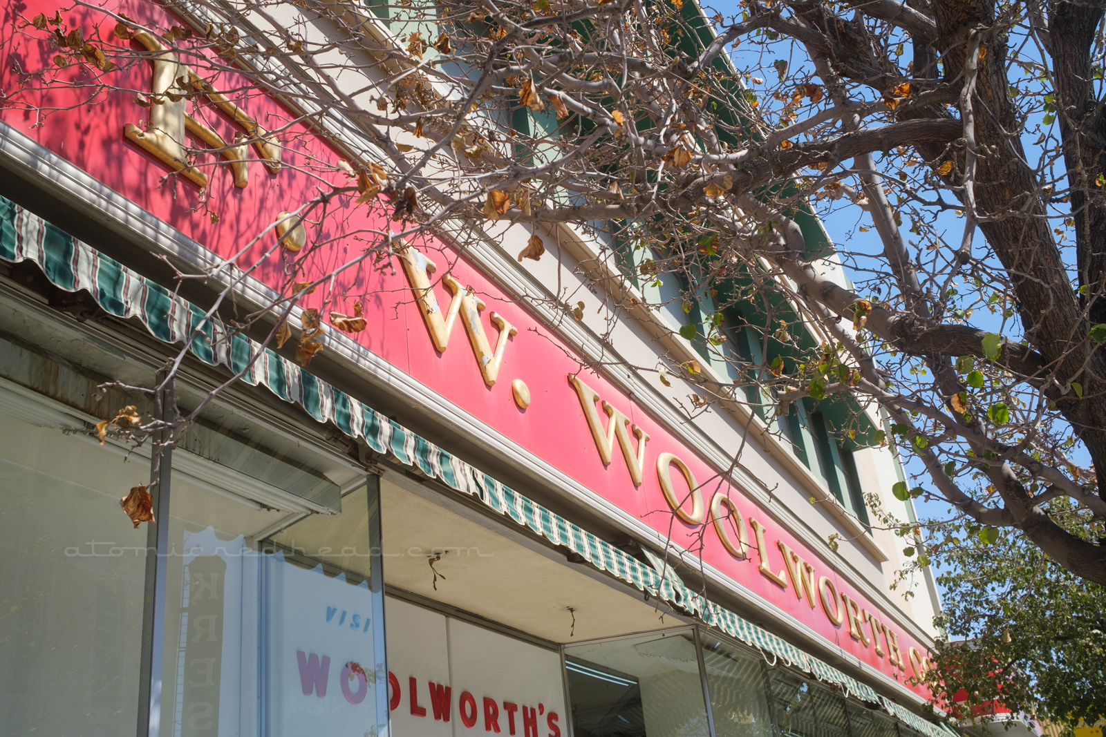 A long red sign stretches the length of the building reading "F.W. Woolworth's" in large gold letters.