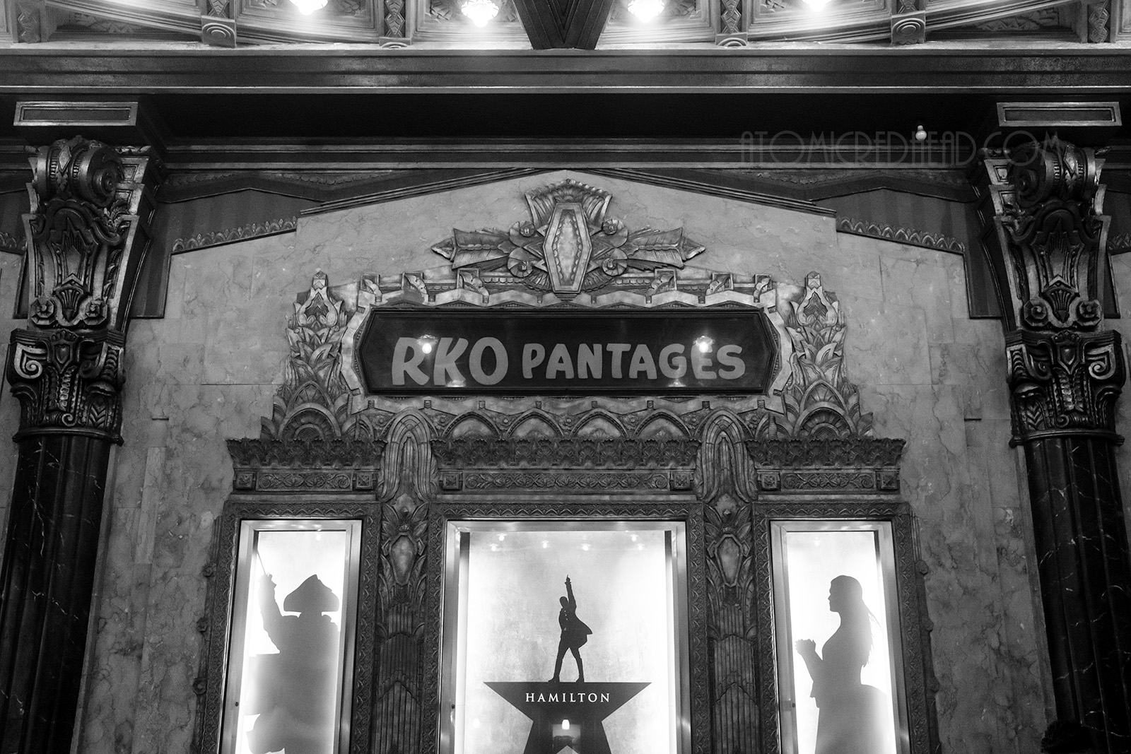 "RKO Pantages" reads above lighted frames that hold Hamilton posters. Everything is framed in wild Art Deco motifs. 