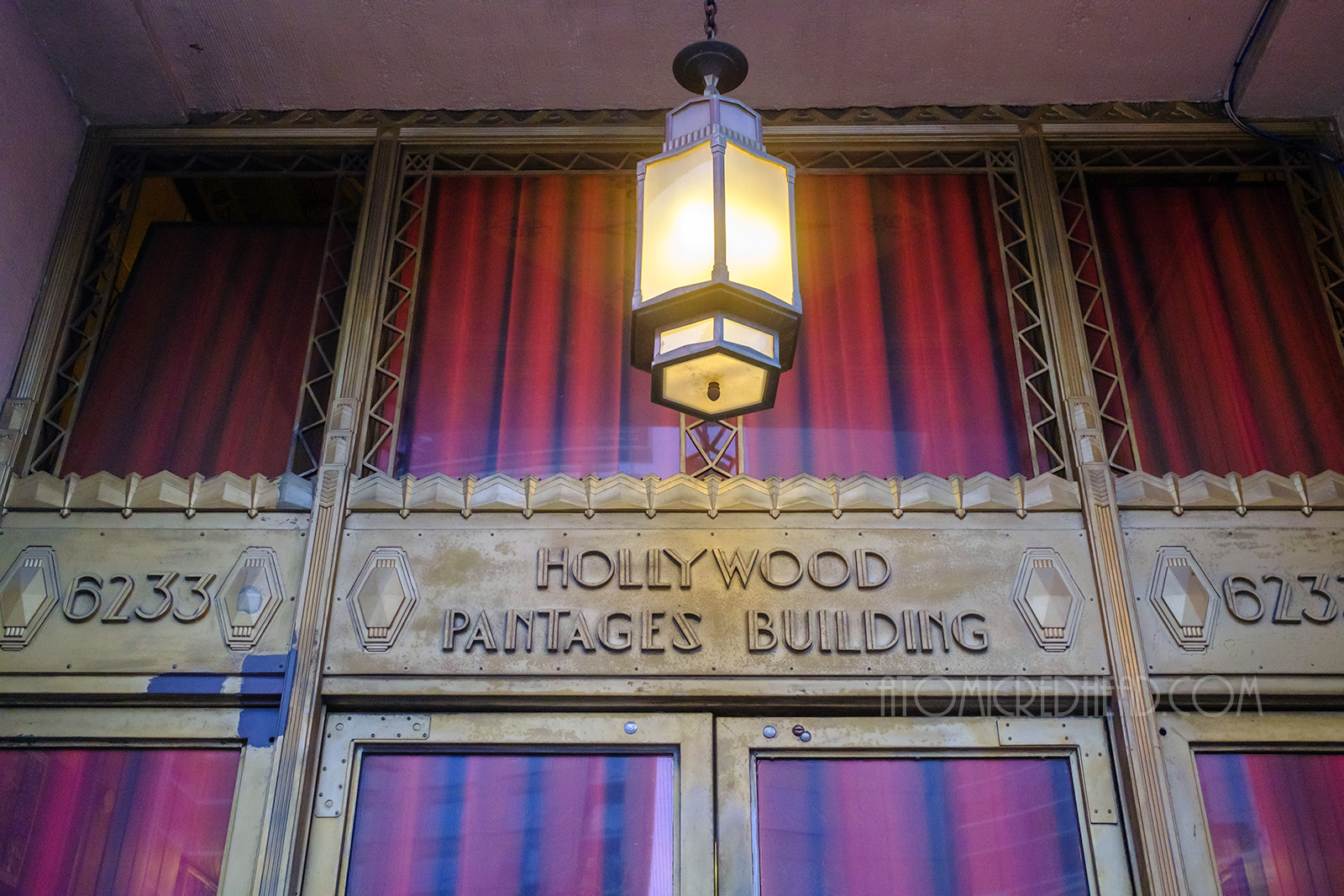 In gold above a doorway reads "Hollywood Pantages Building" in a crisp Art Deco font.