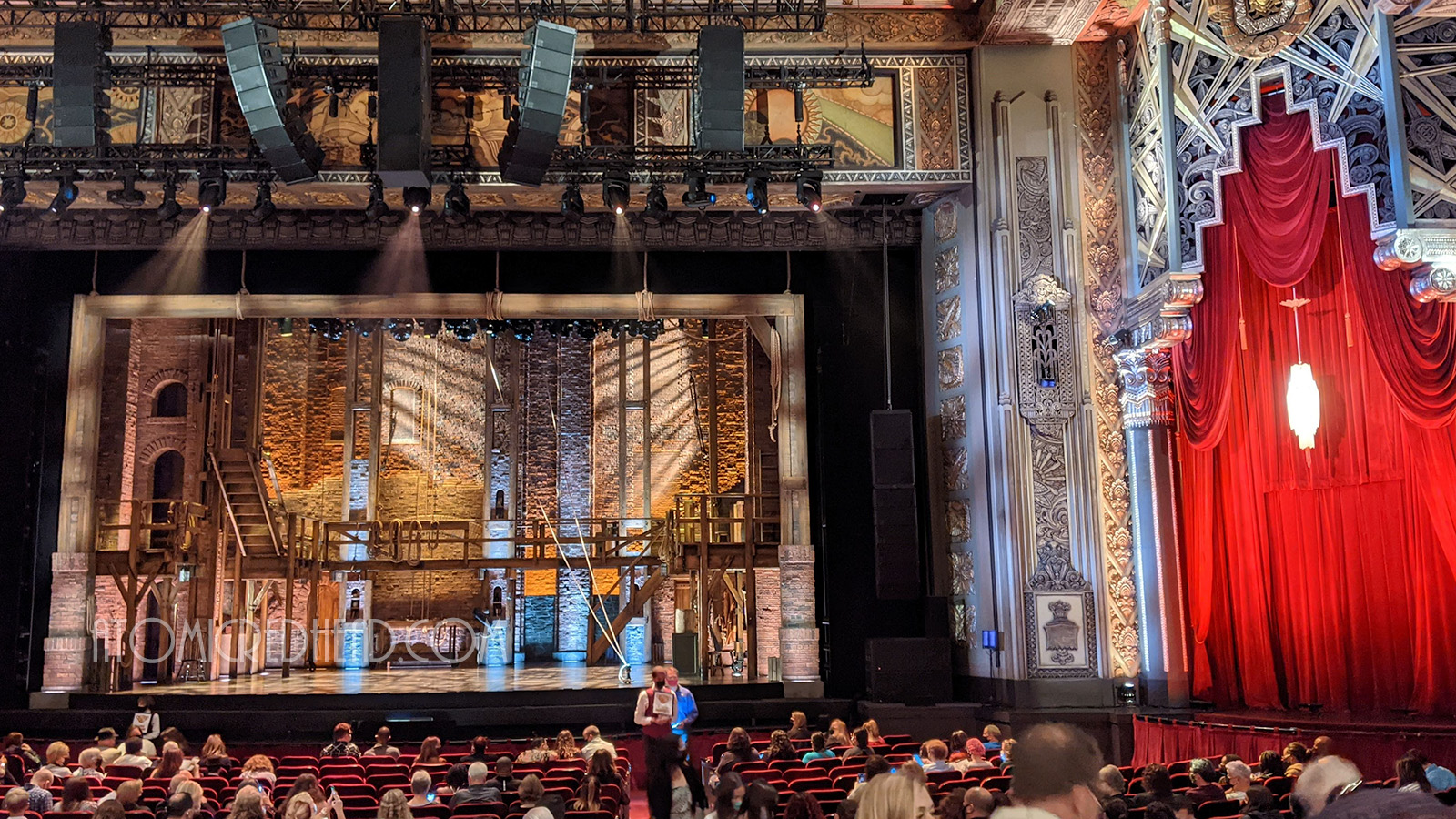 The stage is set for Hamilton, a brick background with a U-shaped wooden platform.