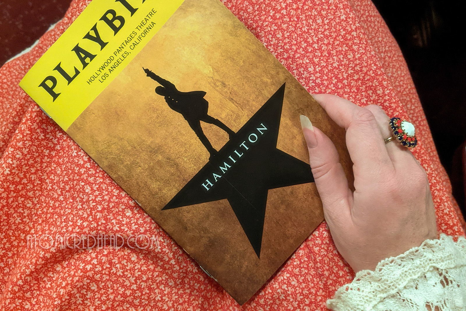 Playbill for Hamilton, which features a black star, but instead of a point at the top, stands the silhouette of a man with his hand in the air.
