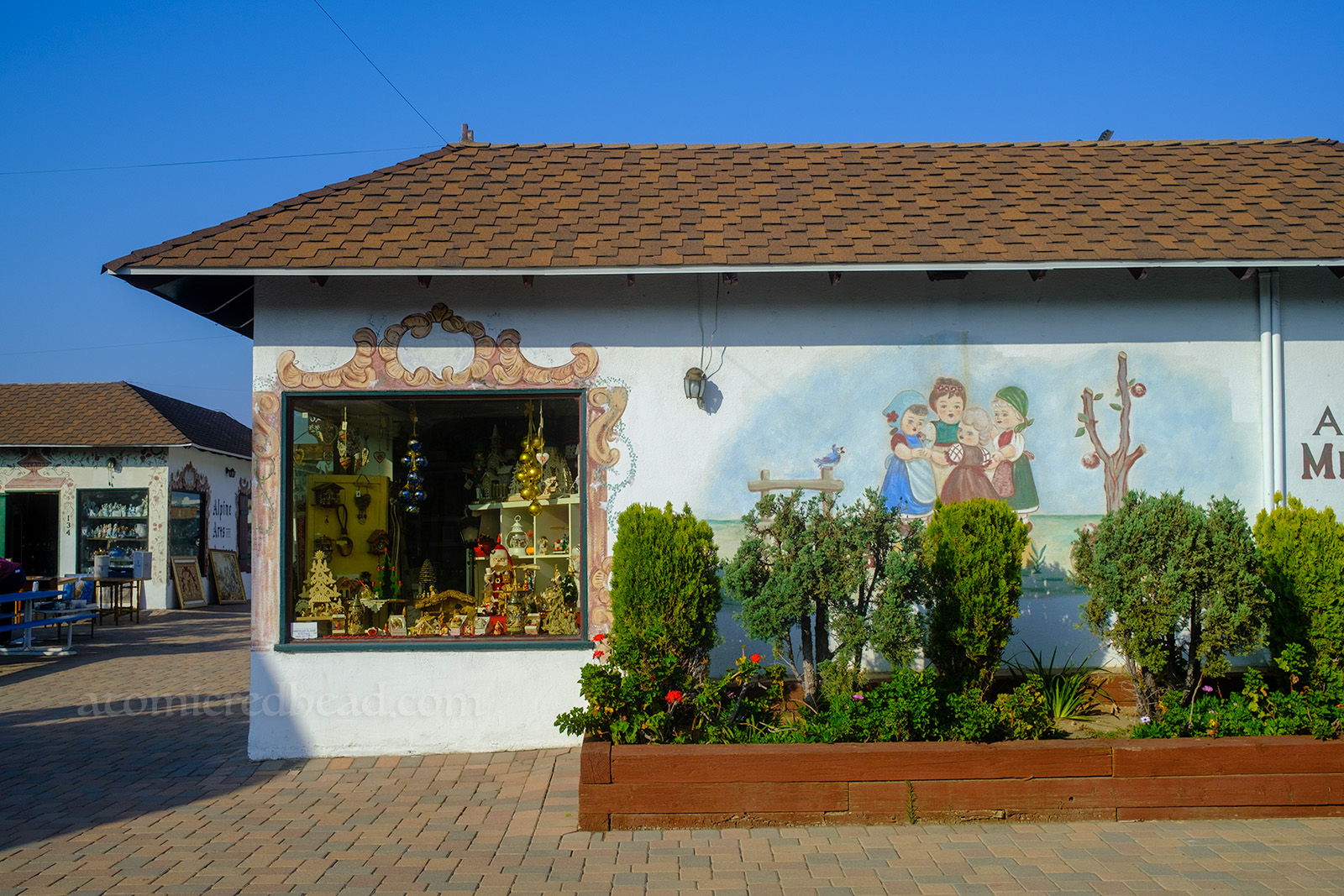 A mural of children playing is on the side of the toy shop.