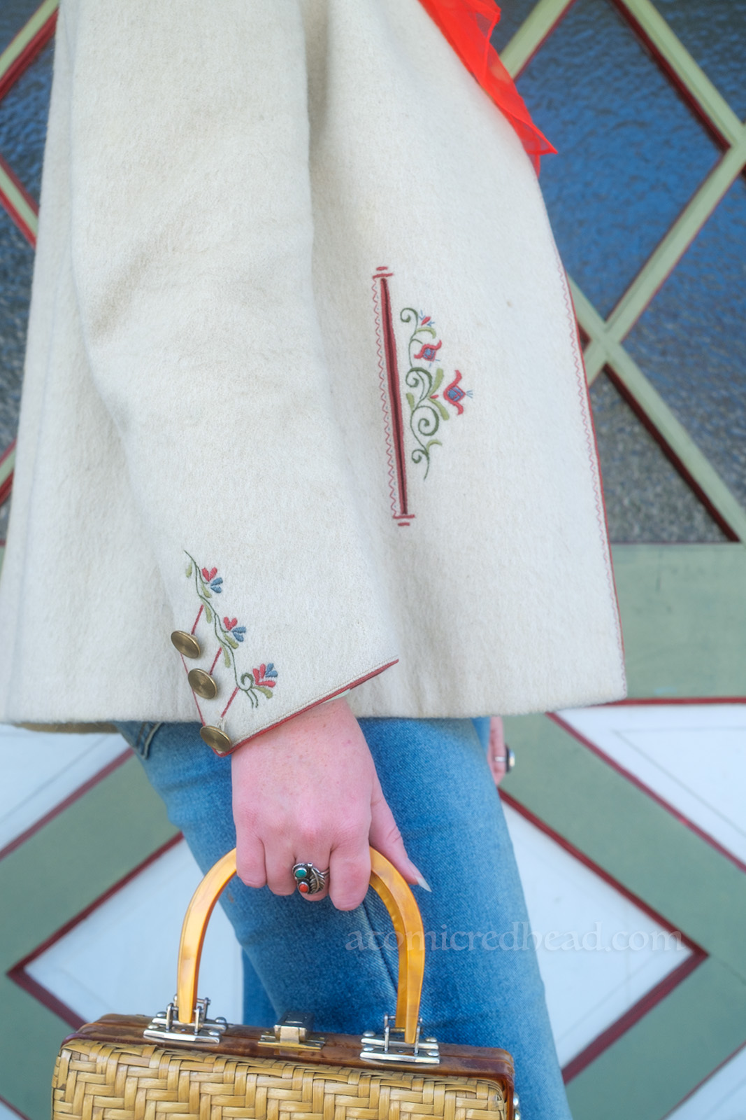Close-up details of my jacket. Around the pocket and cuff are red, green and blue embroidered flowers.