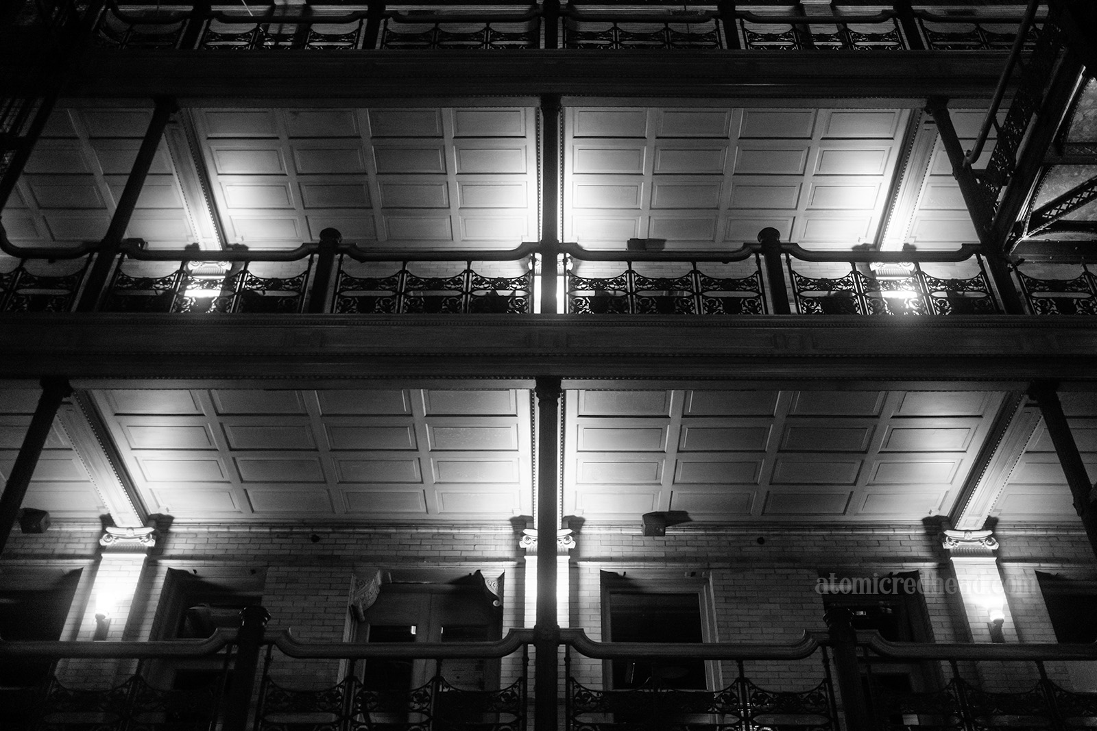 Black and white photo of two floors' blaconies.