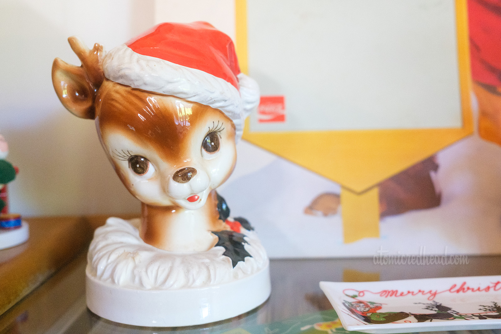 Close-up of a ceramic reindeer head with a Santa hat on.