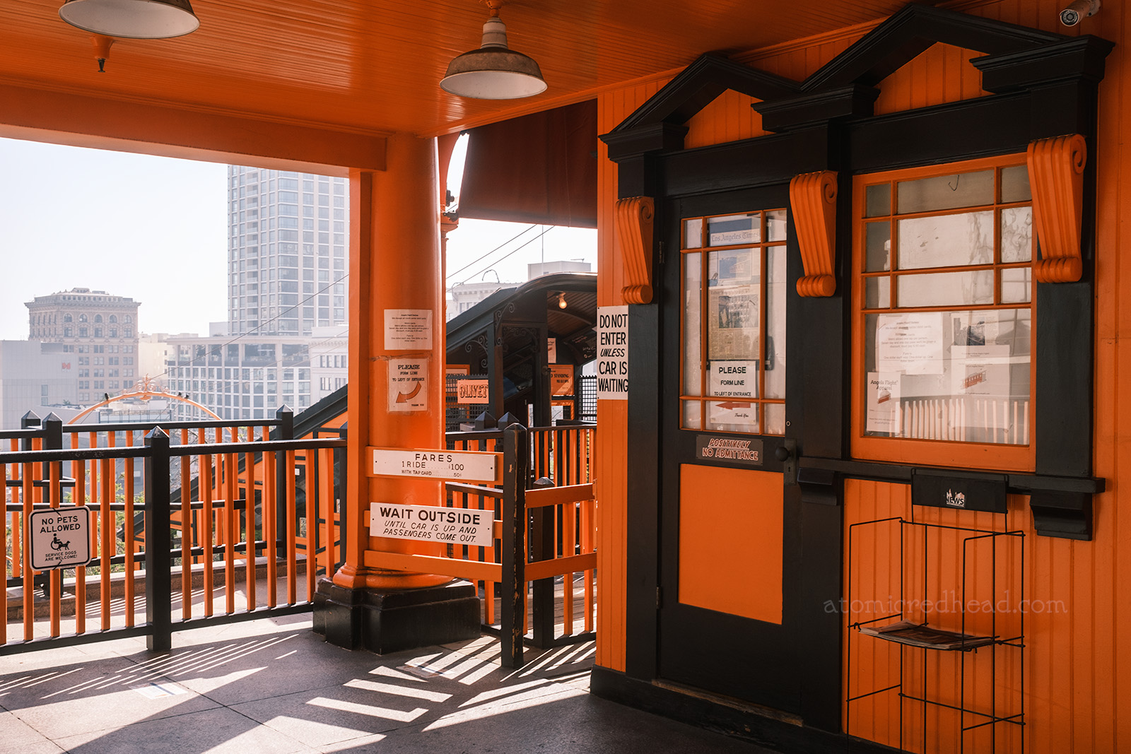 The upper station, an orange building with black trim on the ornate doors and windows.