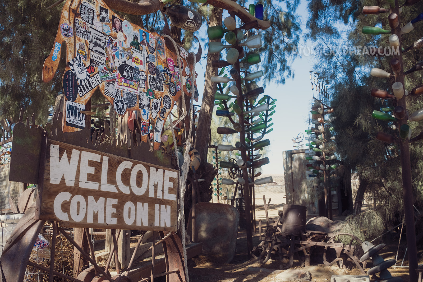 A large painted sign reads "Welcome Come On In" in large white letters, welcoming visitors to Bottle Tree Ranch.