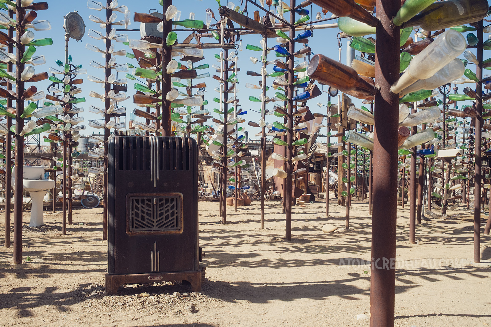 An old radiator makes up the base of a bottle tree.