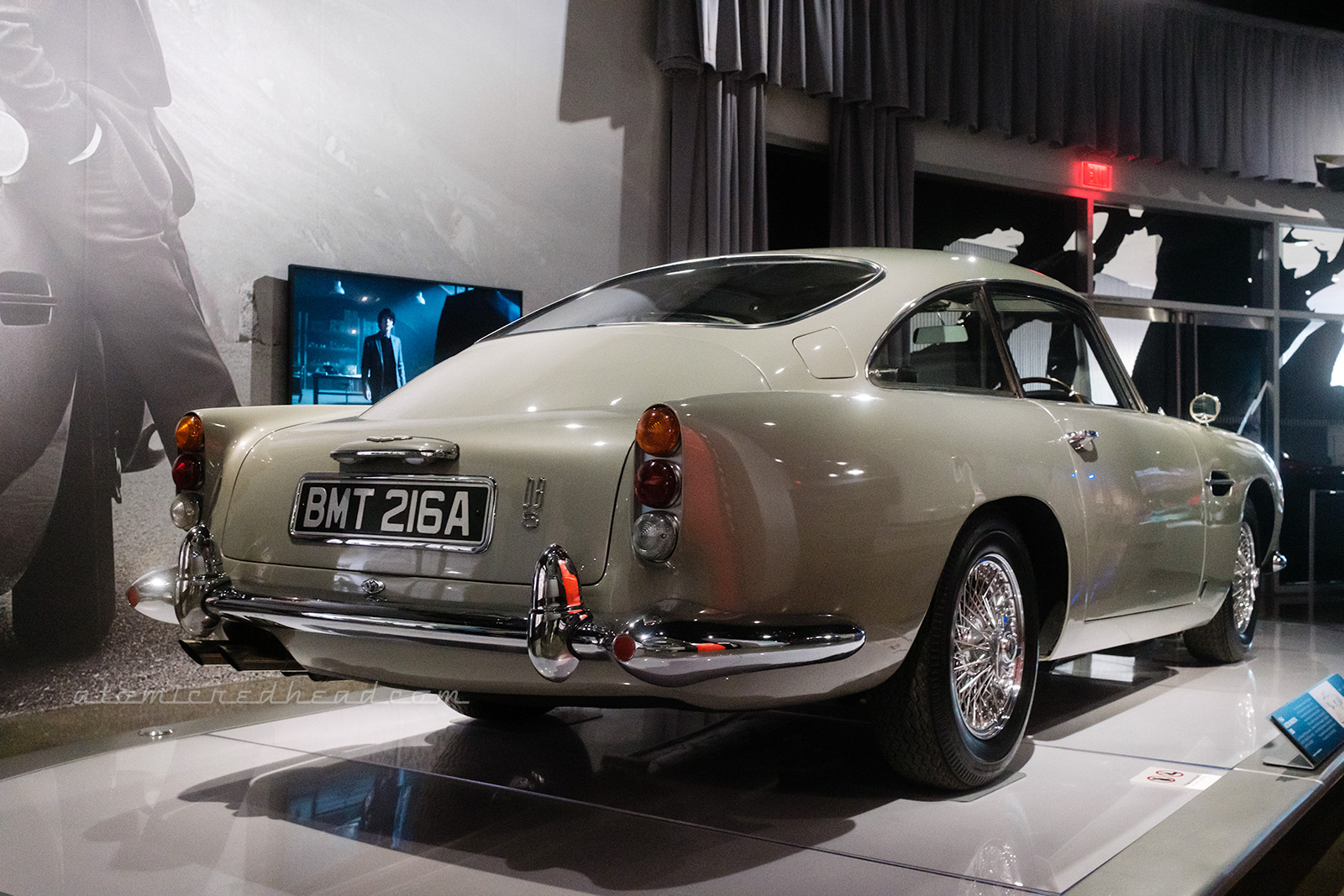 The classic silver 1964 Aston Martin DB5, as seen in various James Bond films, the two door sports car sits with small taillights that rise upward slightly from the back.