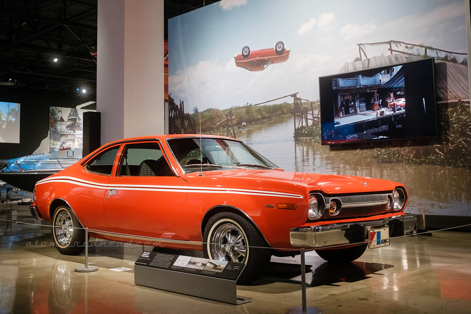 The 1974 AMC Hornet Hatchback as seen in the incredible spinning jump in The Man with the Golden Gun. The orange car features small yellow stripes along the upper side.