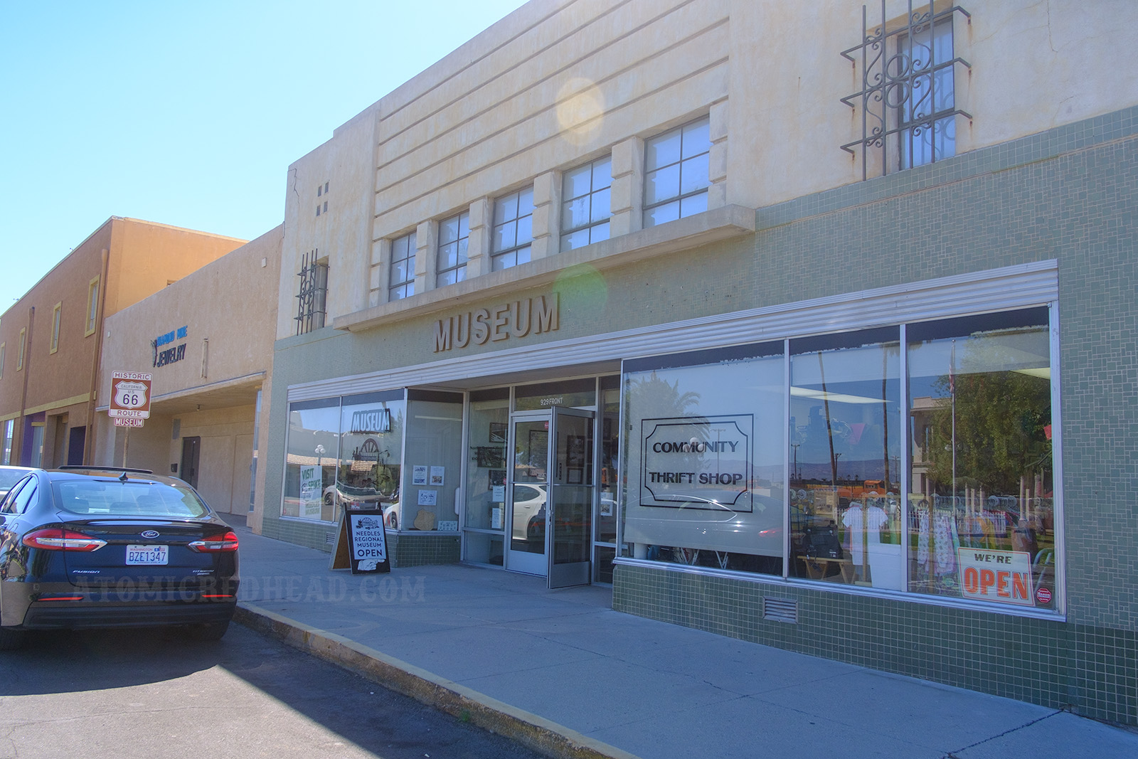 Front of the Needles Regional Museum, a late Streamline Moderne building, with letters reading "MUSEUM" above a set of doors.