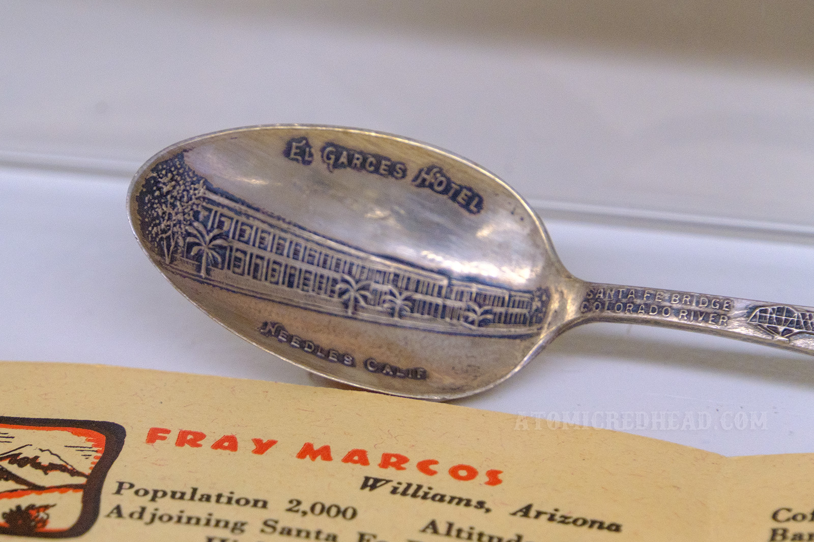 Close-up of a souvenir spoon featuring the El Garces Hotel.