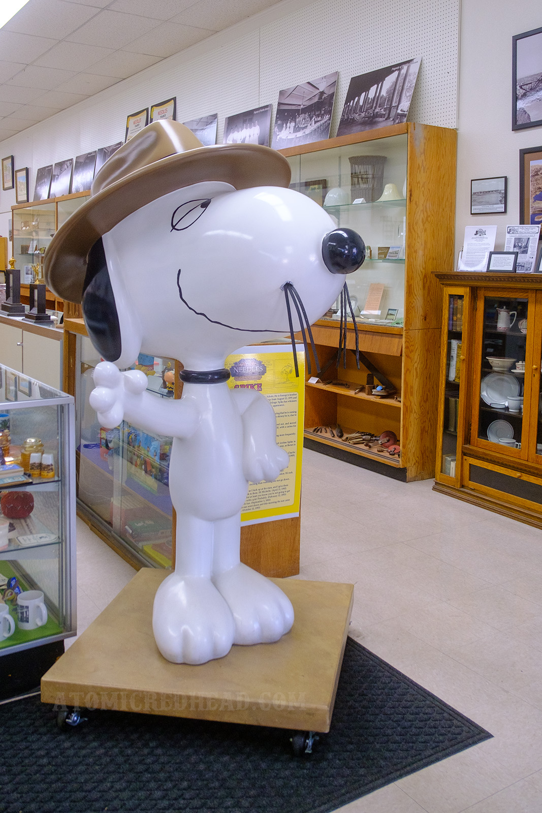A large statue of Snoopy's brother, Spike, a skinny beagle, wearing a brown fedora and long droopy whiskers.