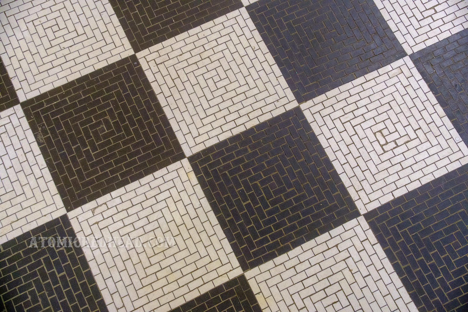 Close-up of the tiles, which upon closer inspection, each black or white square is made up of many small, rectangular tiles. 