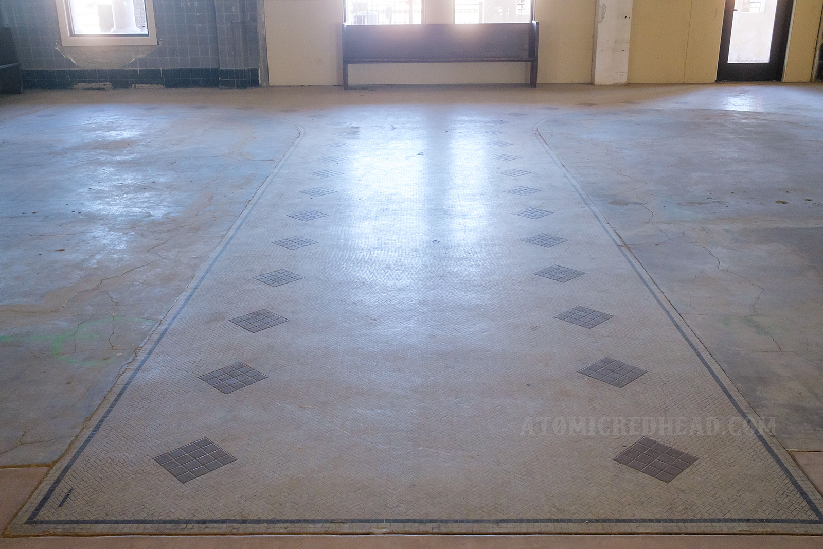 Tile work of two-tone grey shows where the horseshoe shaped lunch counters once stood.