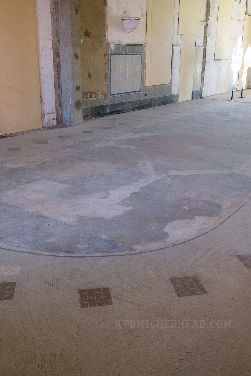 Tile work of two-tone grey shows where the horseshoe shaped lunch counters once stood.