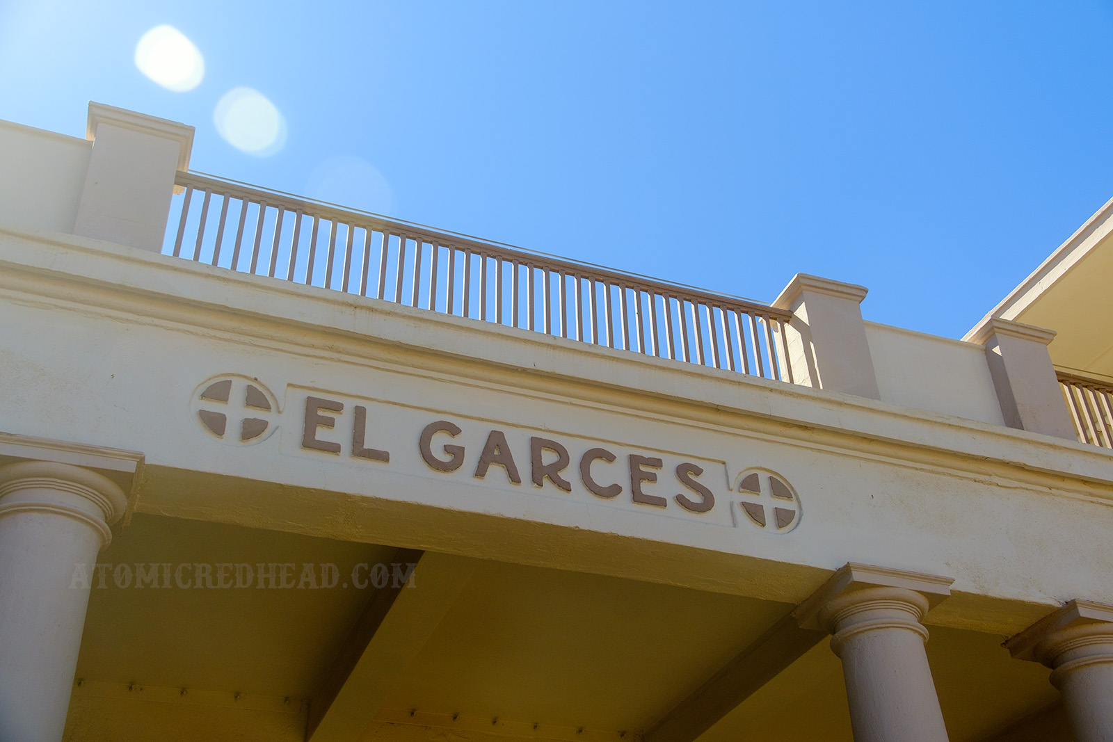 Above the main entrance to the El Garces from the train reads "El Garces" in light brown letters on a cream colored building.
