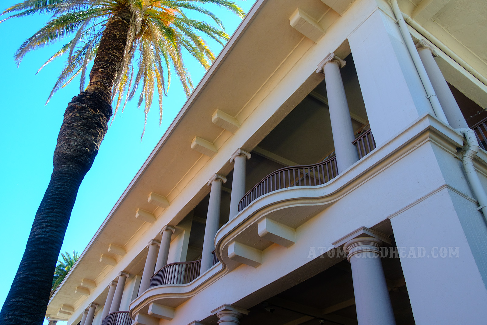 Looking up at the balconies of the second story, some of which curve slightly out.