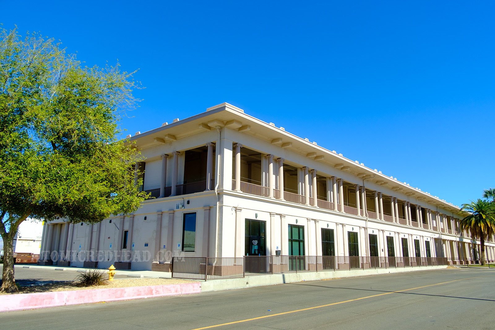 Exterior of the El Garces, a long two story building featuring pillars, and painted cream, with the pillars a light brown.