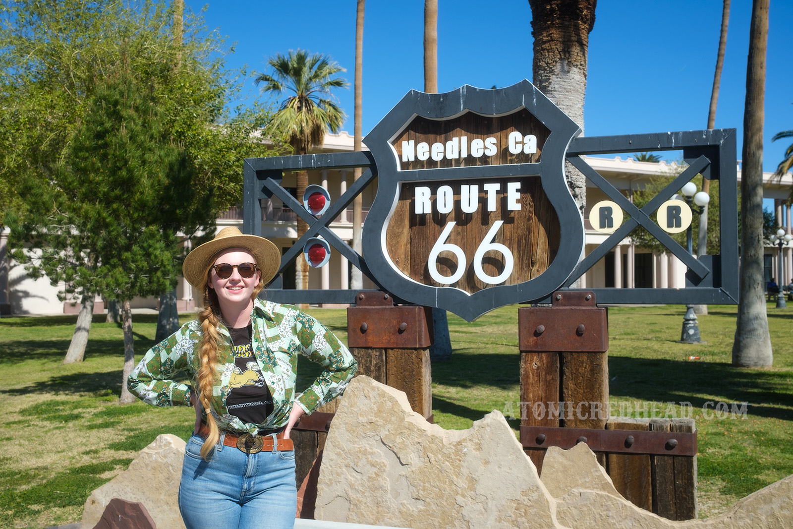 Myself standing in front of a sign reading "Needles, Ca. Route 66" and incorporates elements of the highway sign and railroad crossing signs.