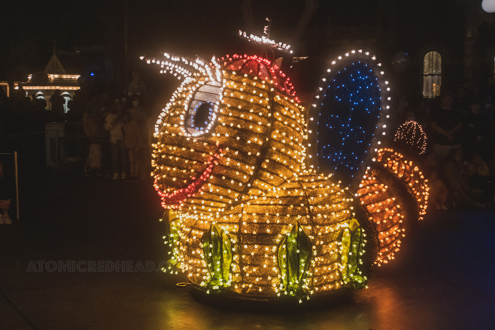 A funny little firefly made up of lights makes his way down Main Street.