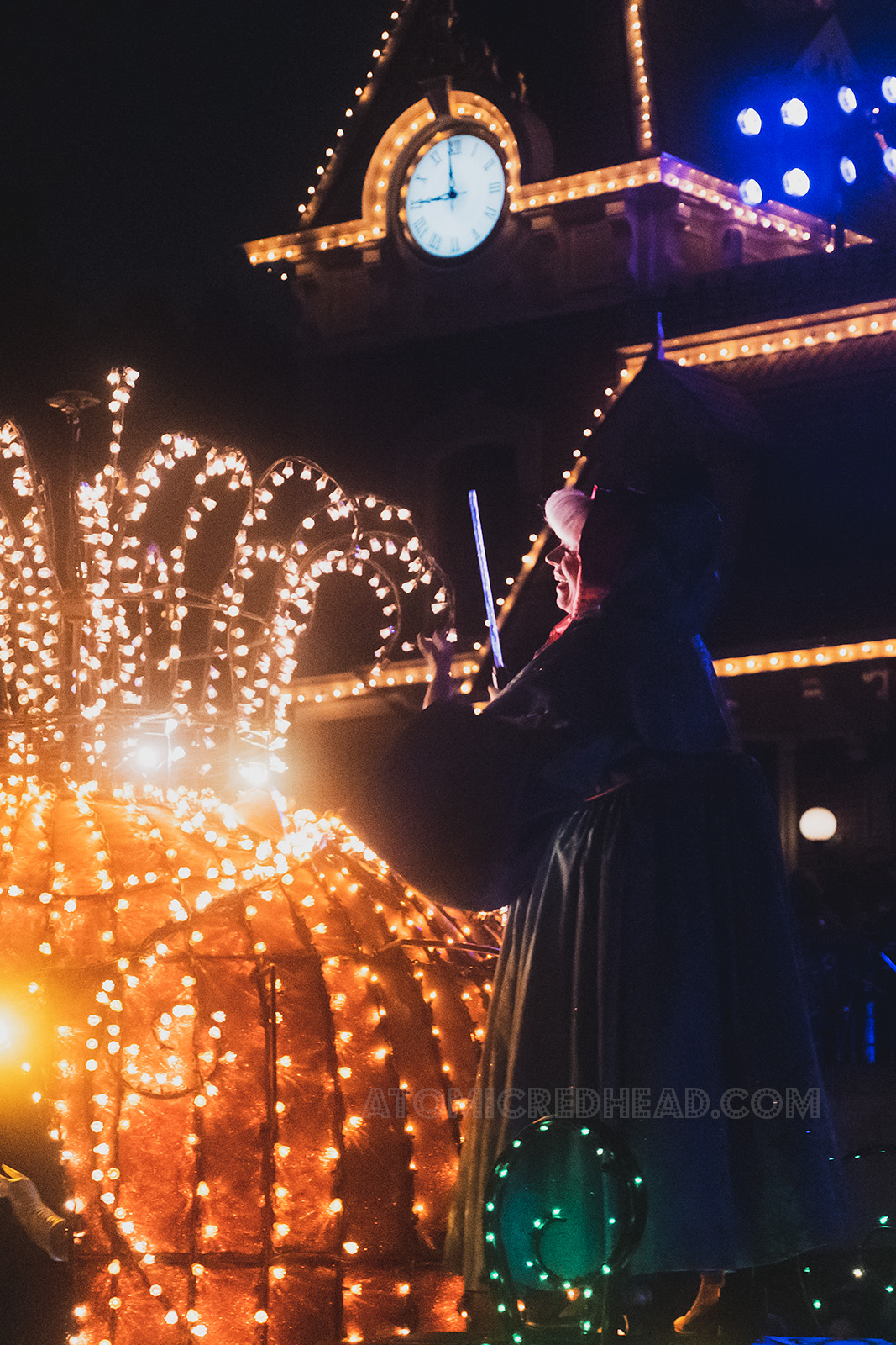 Fairy Godmother from Cinderella waves to the crowd from the back of the pumpkin coach.