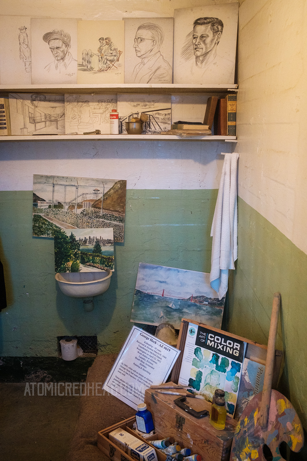 Inside the cell of George Heck Jr., which features several sketches, paintings, and art supplies.