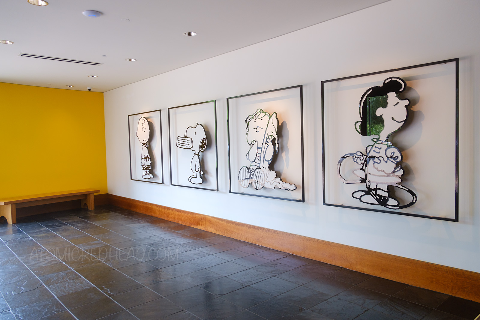 The characters of Charlie Brown, Snoopy, Linus, and Lucy hang on the wall just inside the Charles M. Schulz Museum.