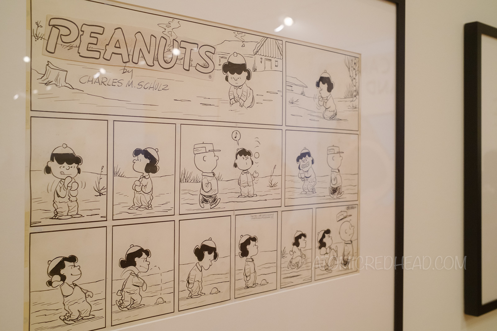 Original comic strip of Lucy forming snow balls, throwing, missing Charlie Brown, then going up to him and kicking him.