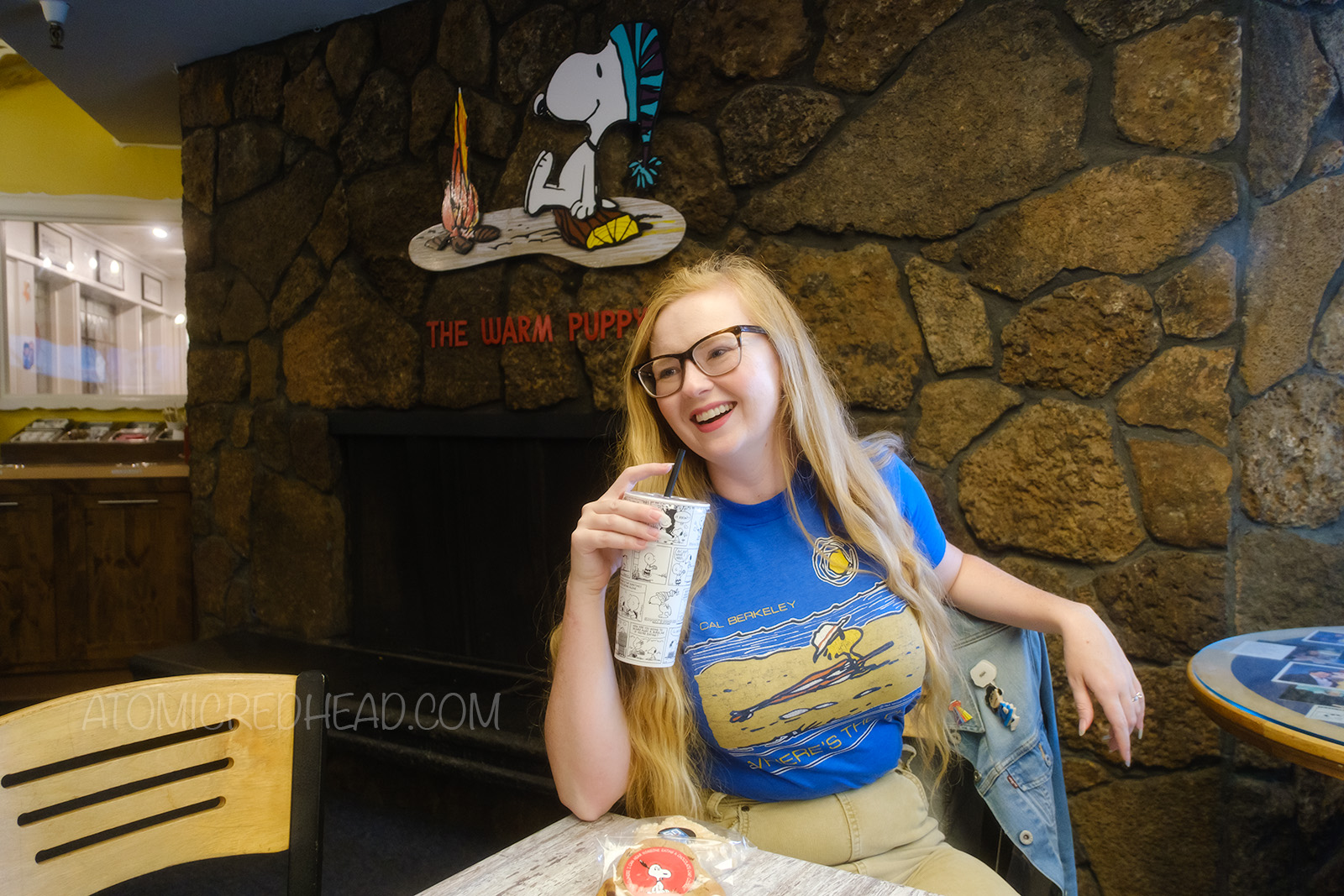 Myself seated at the Warm Puppy, with a fireplace behind that features Snoopy at a campfire and reads "The Warm Puppy Cafe" above.