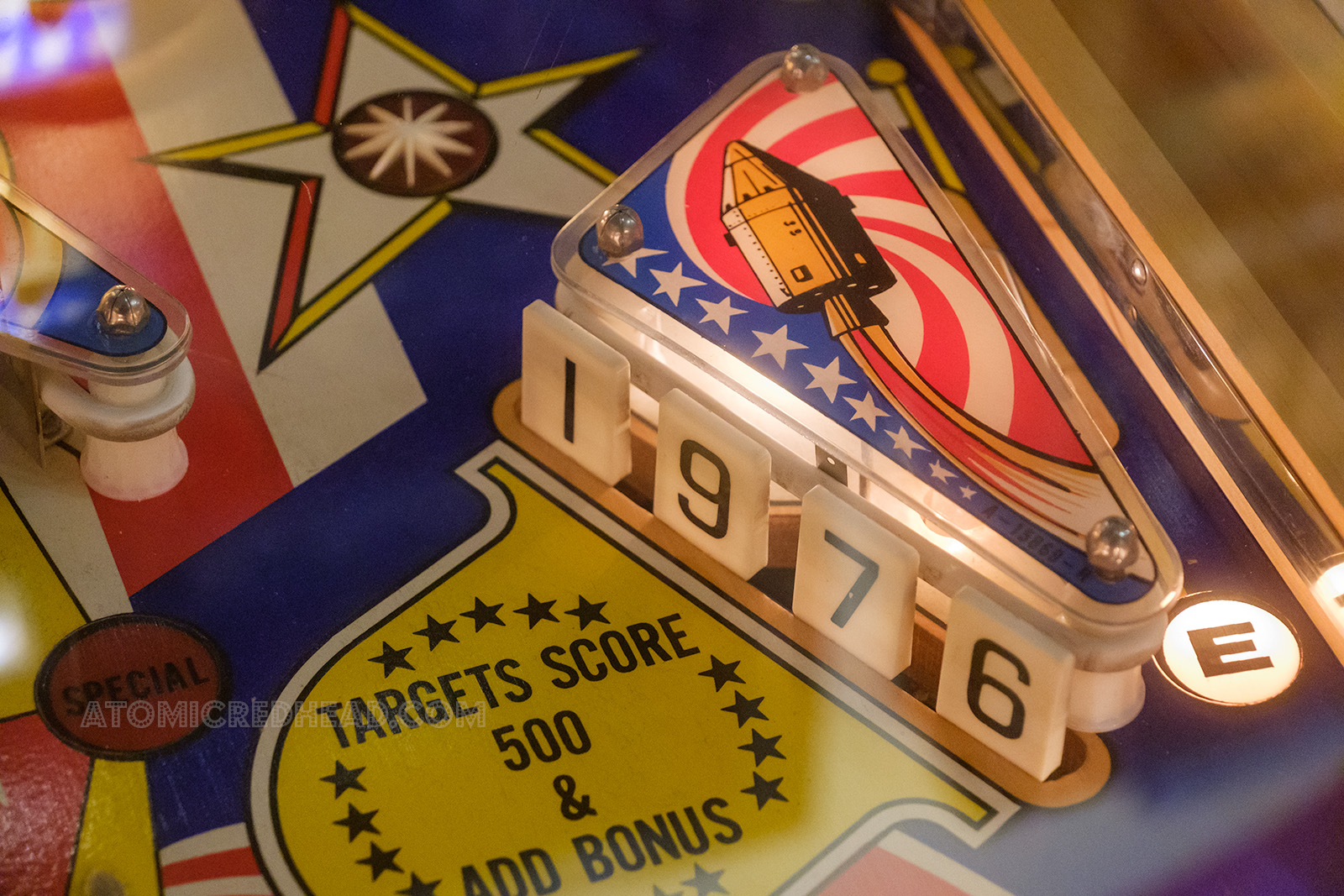 Close-up of a portion of Spirit of '76 themed machine, which features knock-down portions that read "1976" with a space capsule flying over.