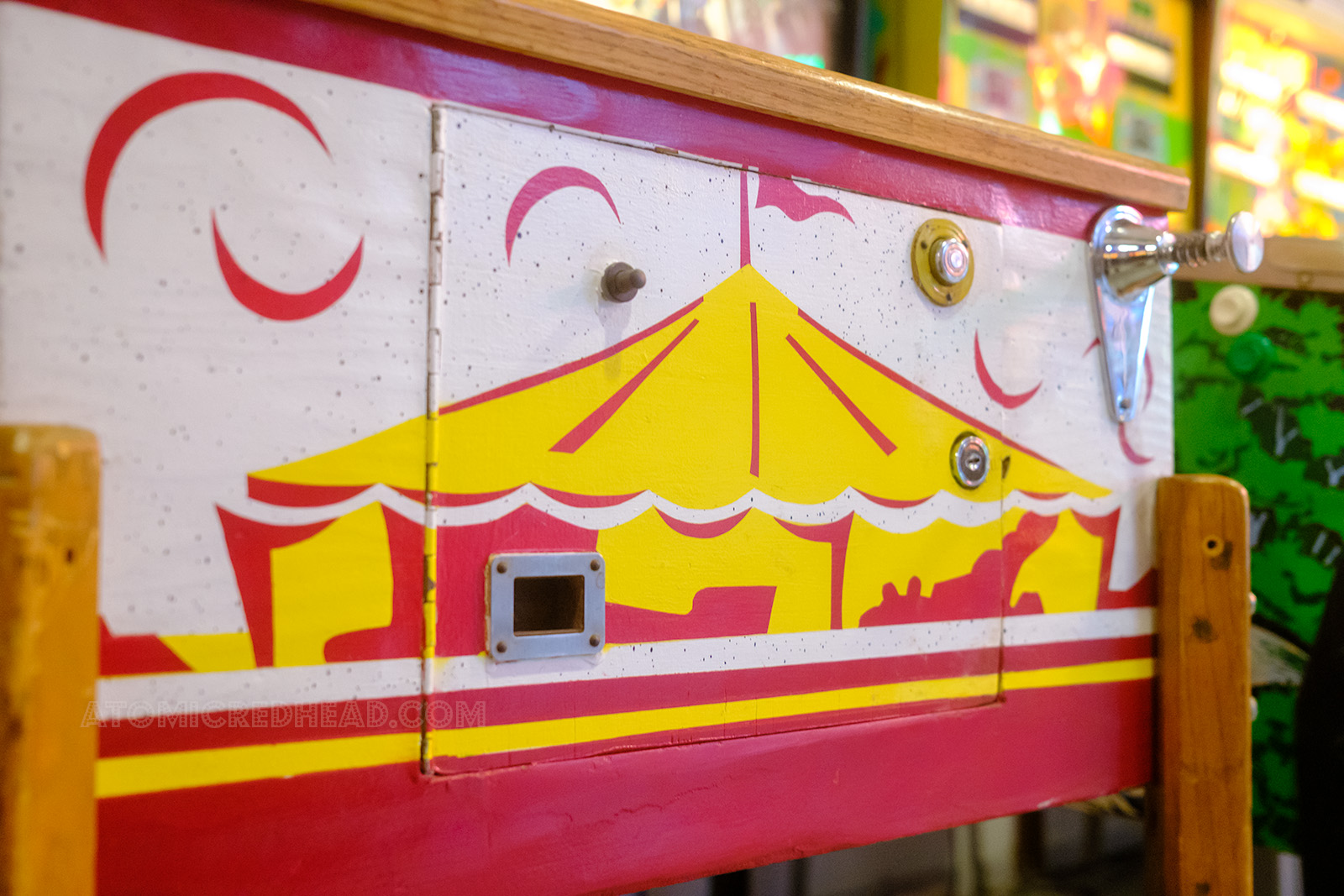 Close-up of the front of a machine which features a stenciled circus tent in red and yellow.