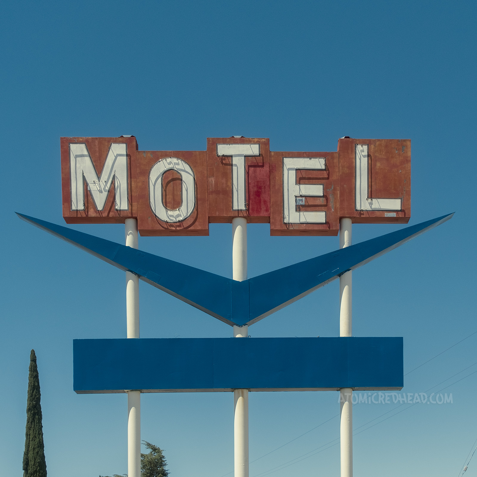 Red blocks read "Motel" with a dark blue chevron shape below.
