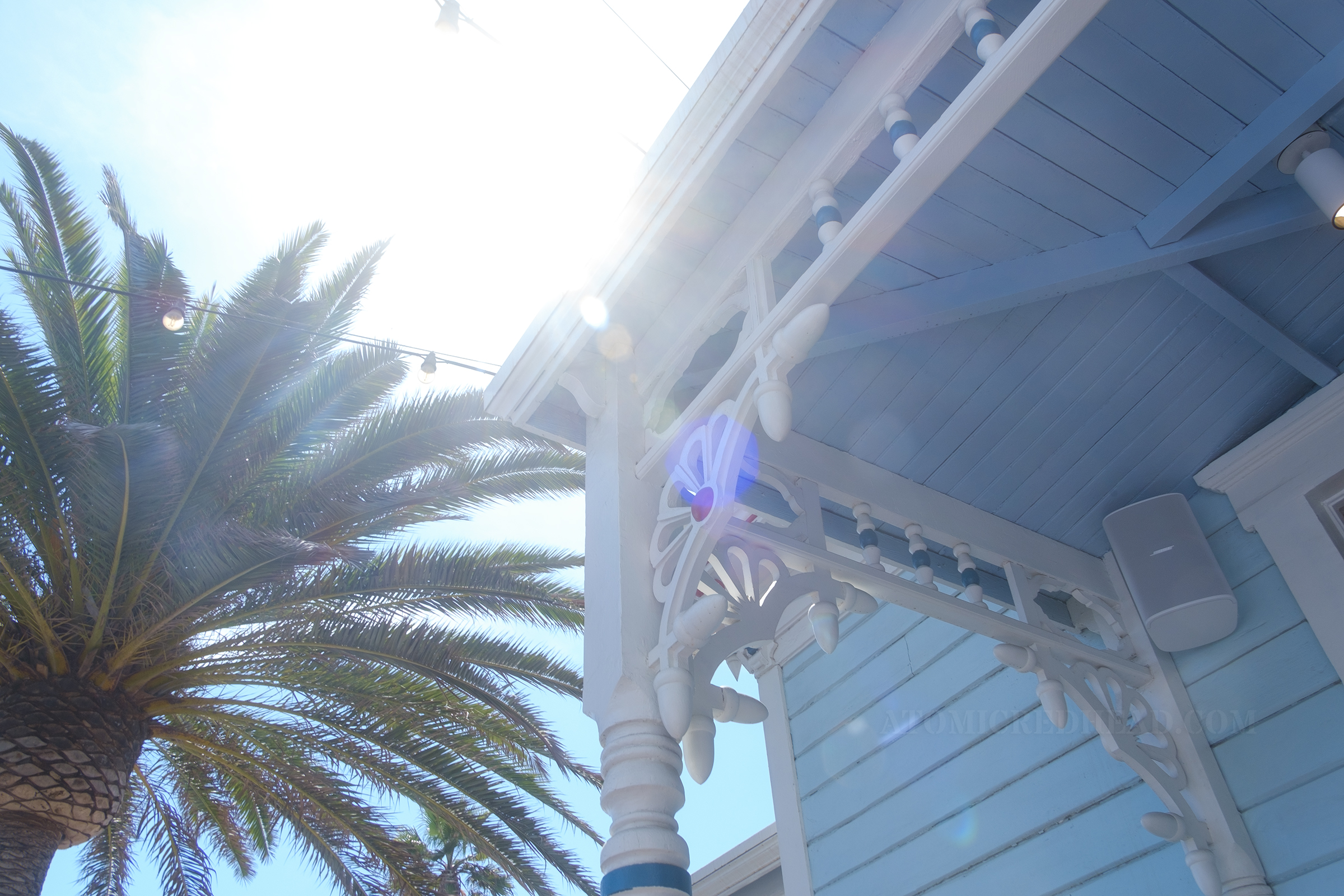 Detail of the corner of the porch, featuring intricate white gingerbread details.