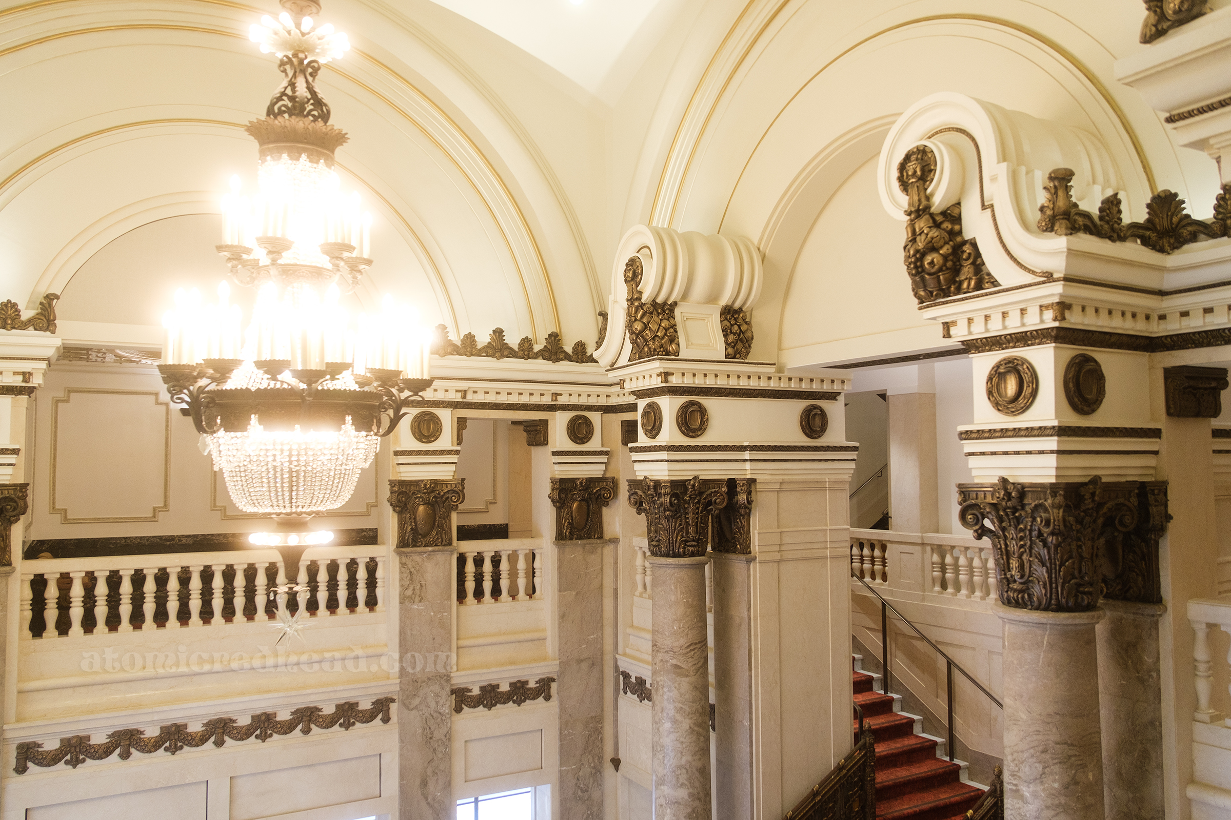 View of a crystal chandelier that hangs in the lobby space.
