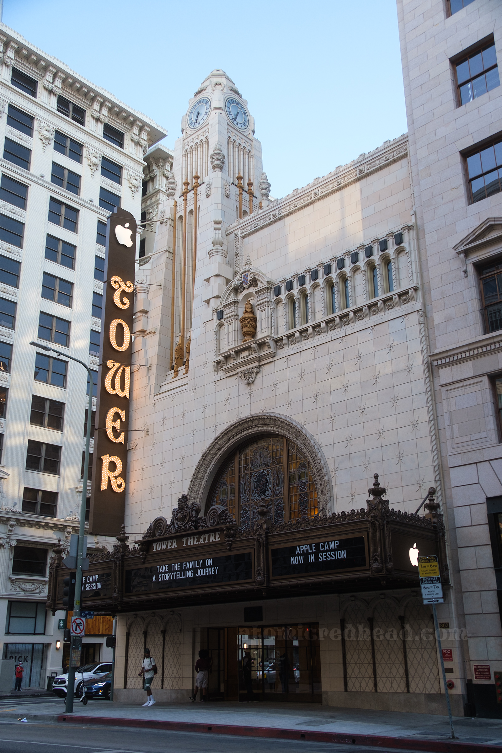 Angled view of the front of the store, which is white and features a dark marquee. Details in various architectural styles of Greek, Italian, Moorish.