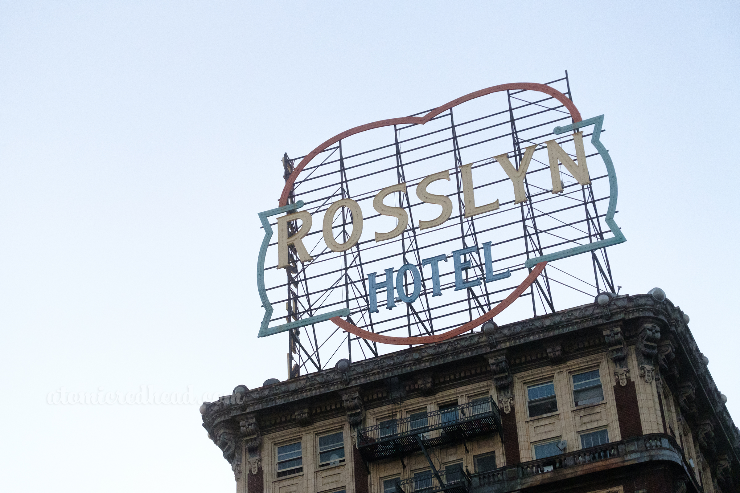 A large heart shaped sign sits atop a roof, reading "Rosslyn Hotel"