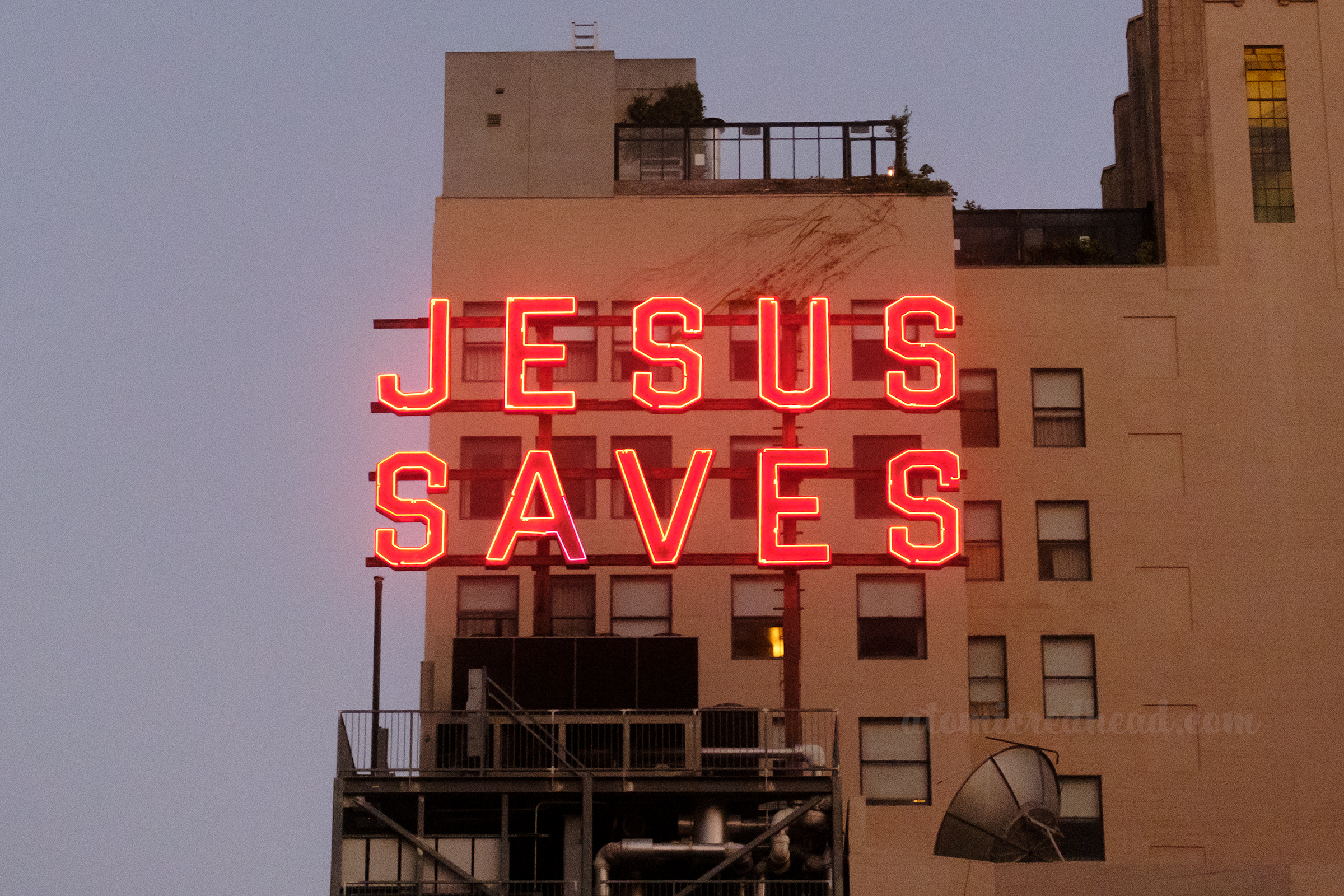 Large red neon letters read "Jesus Saves"