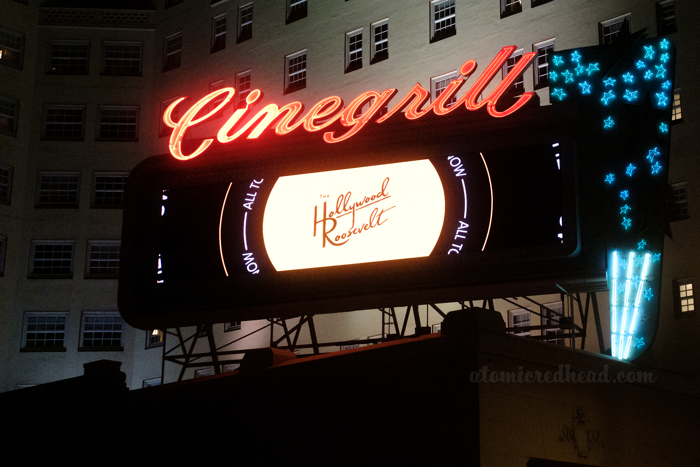 The marquee sign for Cinegrill in red neon, and blue neon stars along the side.