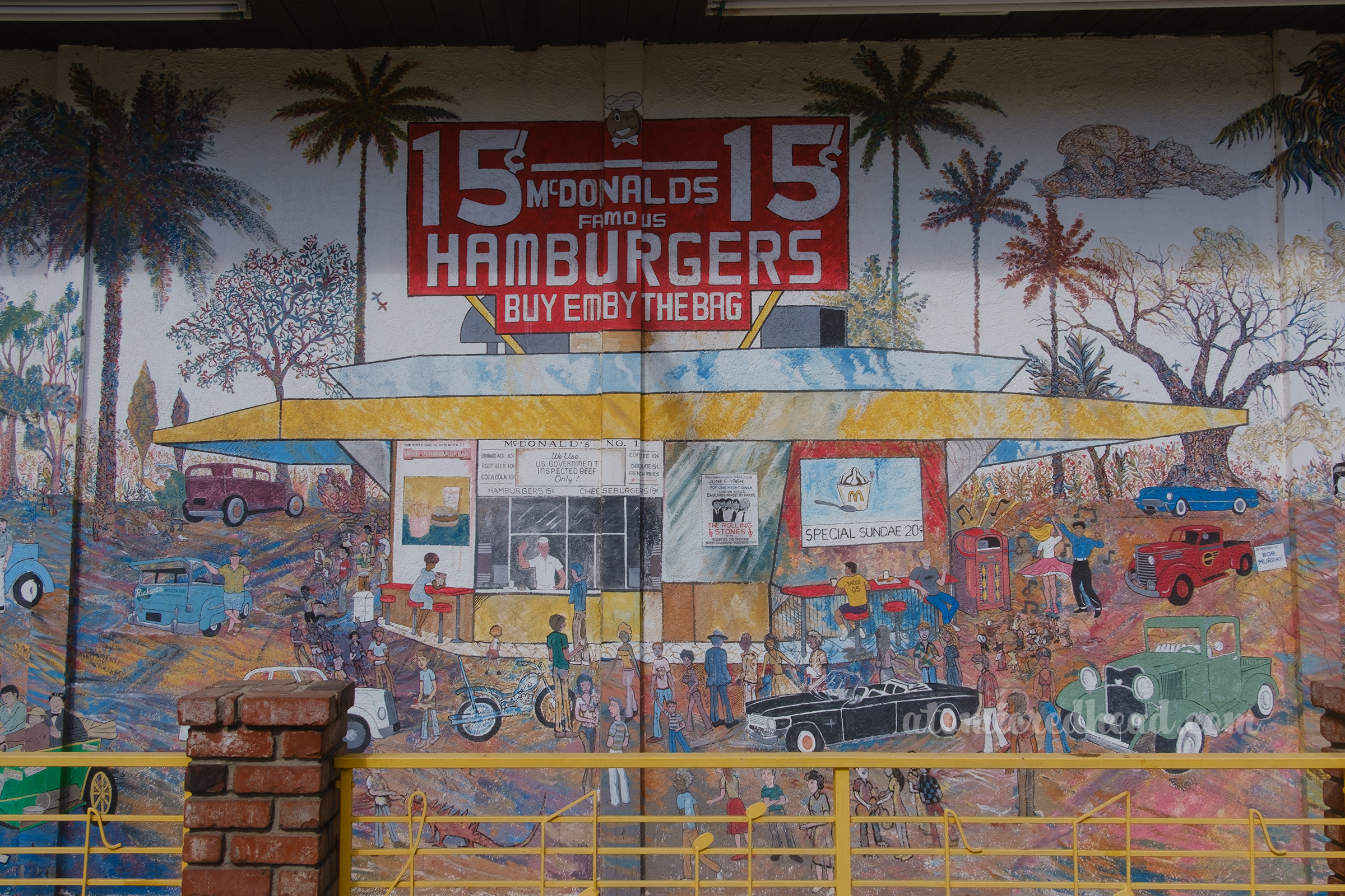 A mural depicts the original McDonald's, with its octagonal building, large red sign reading "15 cent Hamburgers" various 50s cars sit outside.