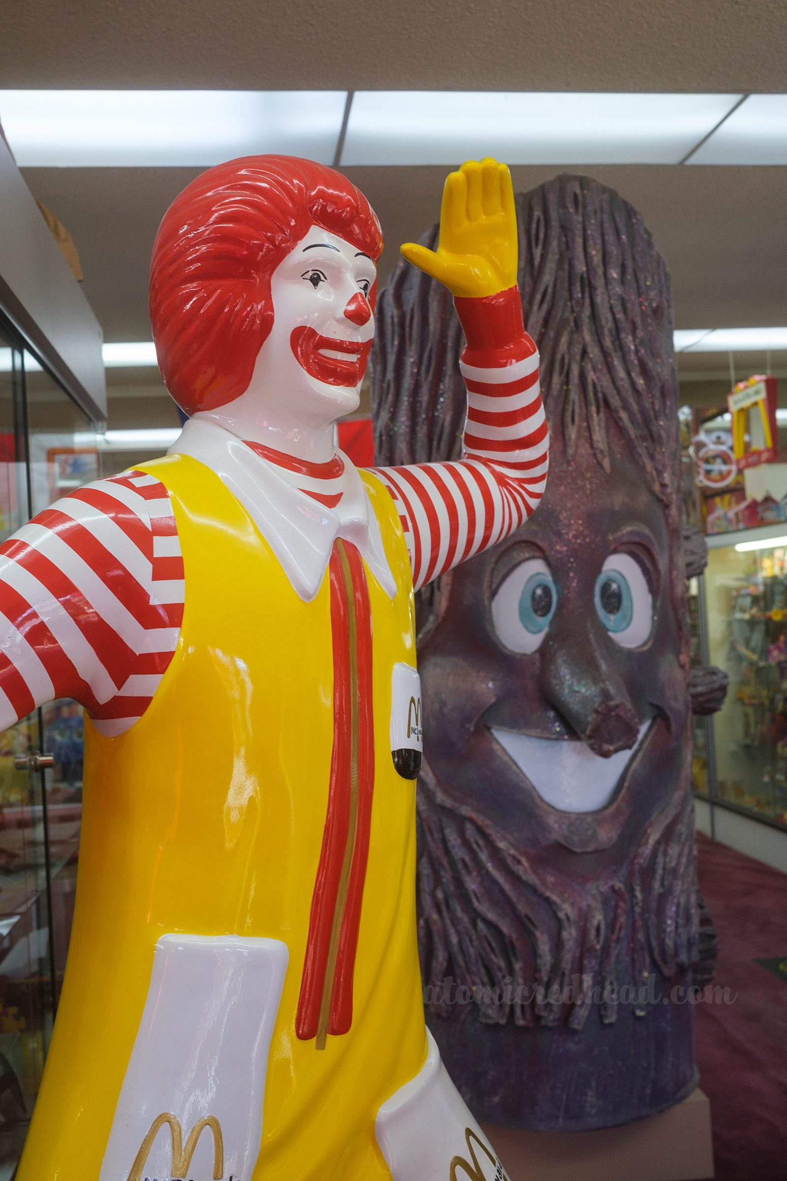 Statue of Ronald McDonald greets visitors, a tree with a face looms behind him.