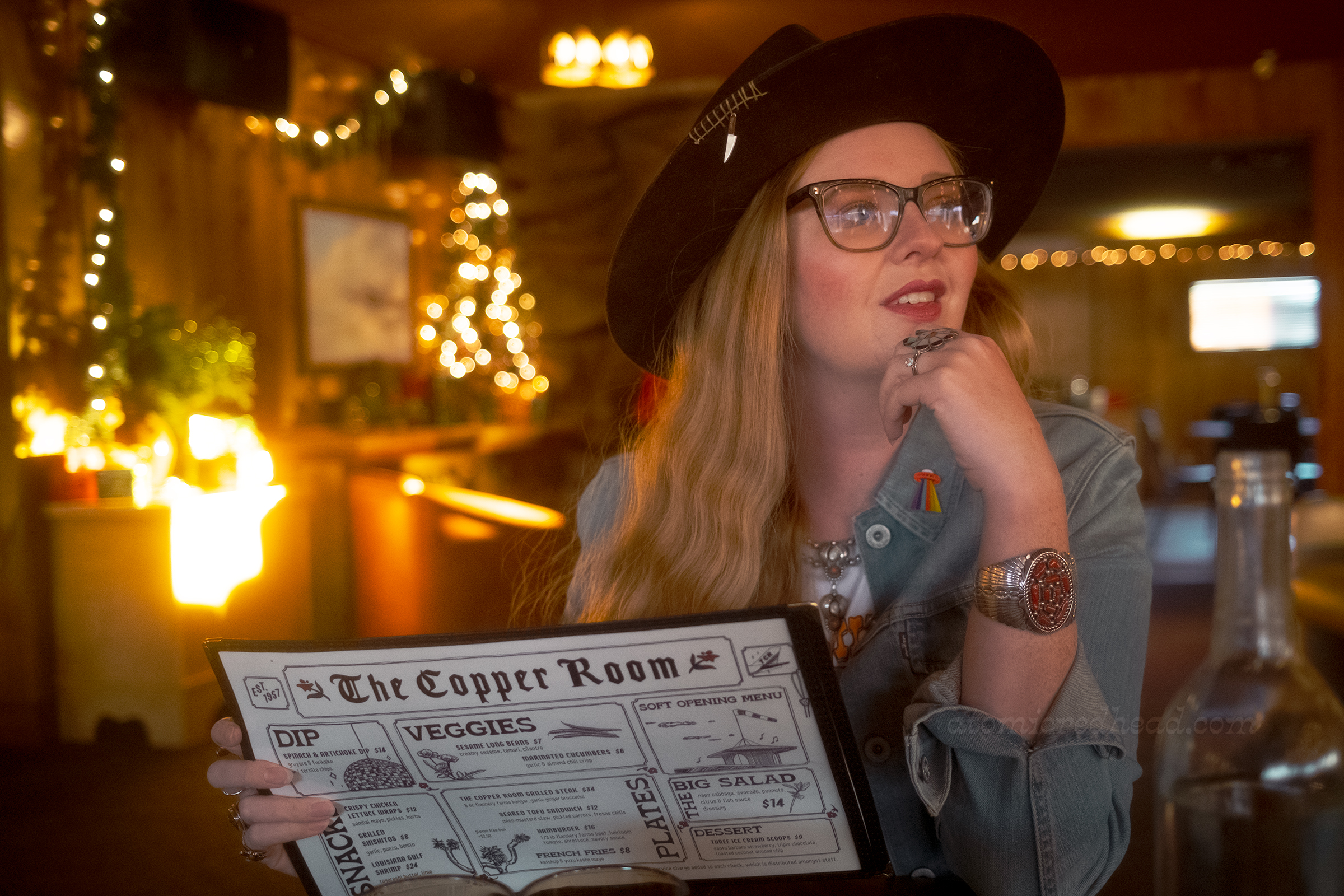 Myself seated inside the Copper Room, holding a menu.