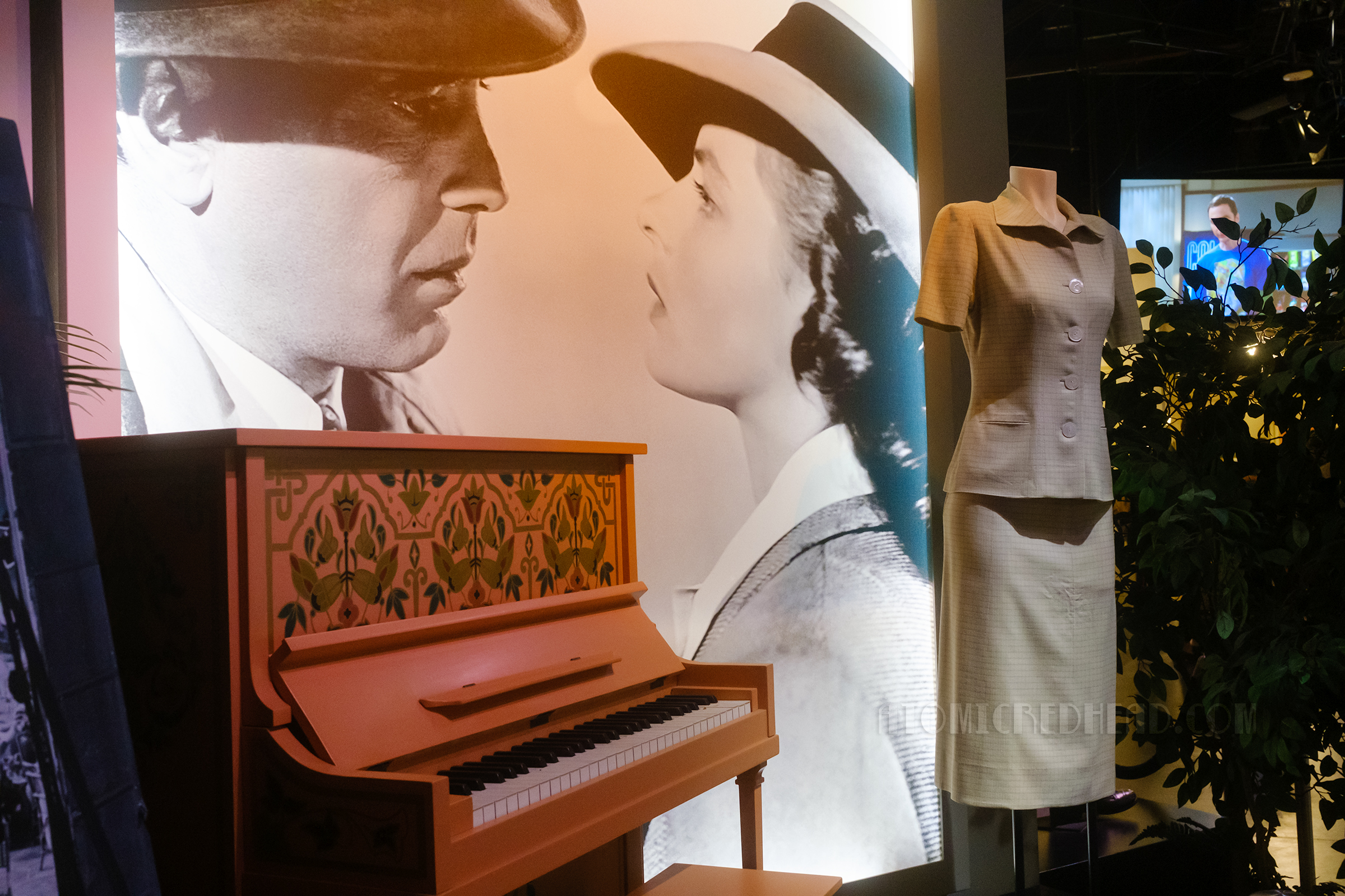 A coral piano rests on the left side of the frame, a grey suit, worn by Ingrid Bergman in Casablanca.